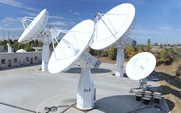 Networking technology shown through four ground antennas pointed at the sky