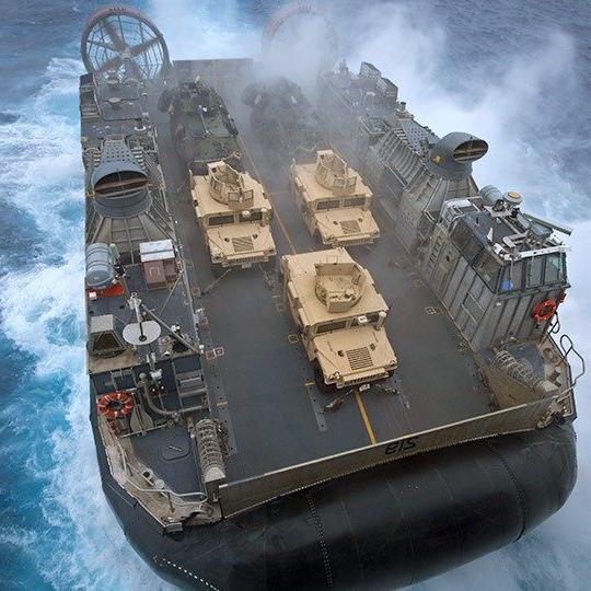 航拍的巨大军用气垫船在海上带有移动天线，载着三辆悍马 