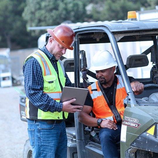 2 construction workers discussion information on a tablet connected with business satellite internet
