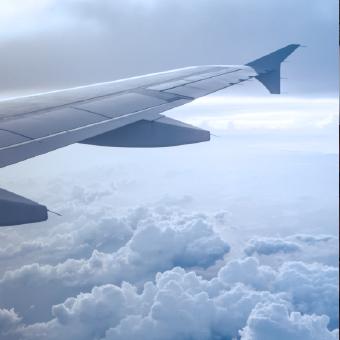 一架飞机的左翼在云层上方飞行的特写