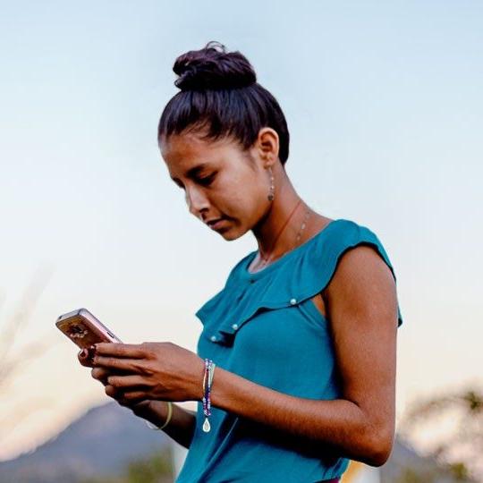 young woman connecting through community internet on mobile