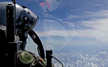 Fighter pilot looking out window of jet